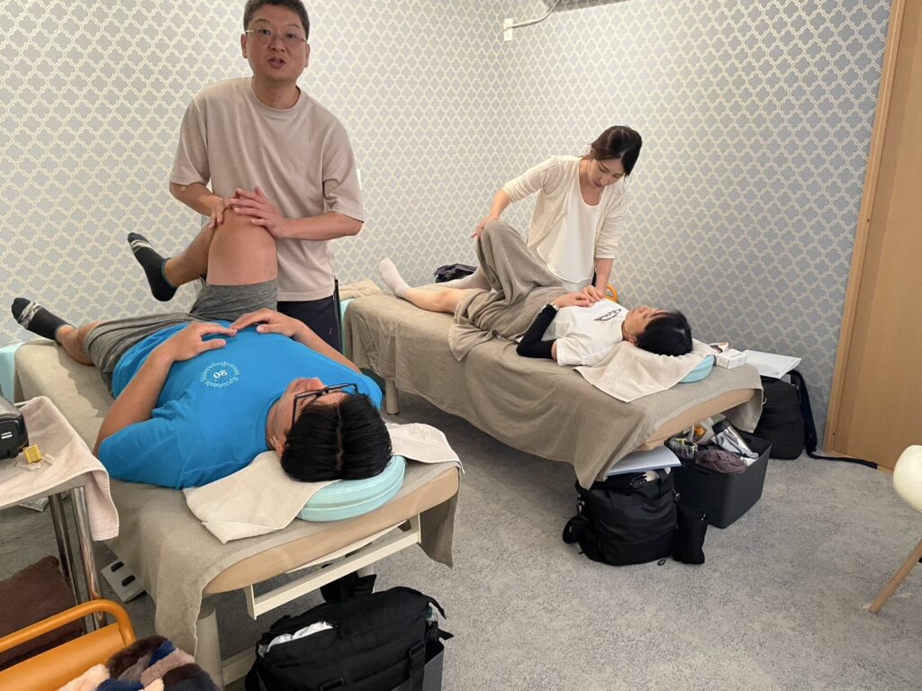 IRT療法 実技指導 股関節検査の様子（参加者が臼蓋形成不全や股関節痛の評価法を学んでいる）
